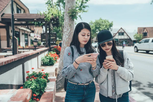 Amigos charlando en teléfonos inteligentes en la calle — Foto de Stock