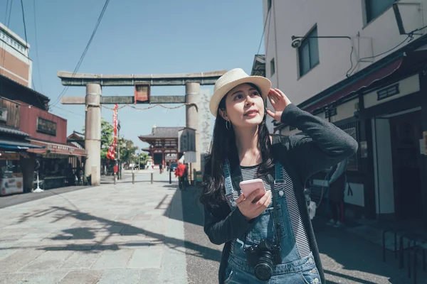 Happy woman walking in street using smartphone — Stock Photo, Image