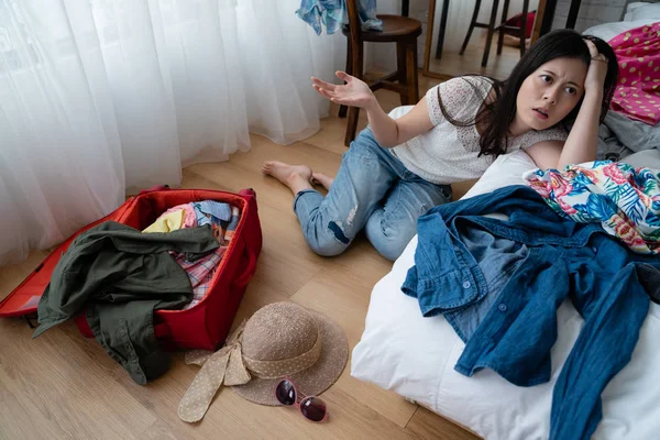 Cansado asiático mujer sentarse en piso cerca cama ropa — Foto de Stock