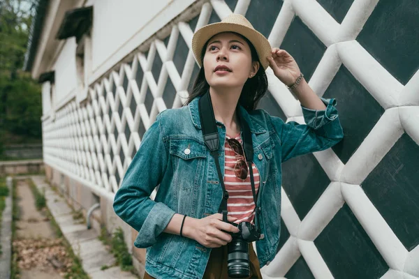 Chica mirar hacia arriba cielo azul brillante por pared gris urbana — Foto de Stock