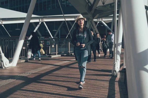 Азиатка туристка прогуливается по пешеходному мосту — стоковое фото