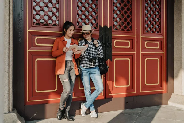 Travelers stand leaning on wall red gate door — Stock Photo, Image