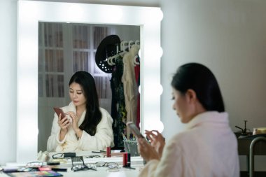 sandalyenin üzerinde oturan ipek Robe Koreli aktris