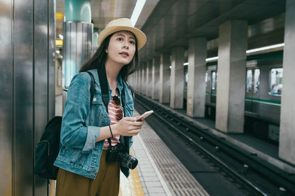 Woman with cell phone waiting on platform — Stock Photo, Image