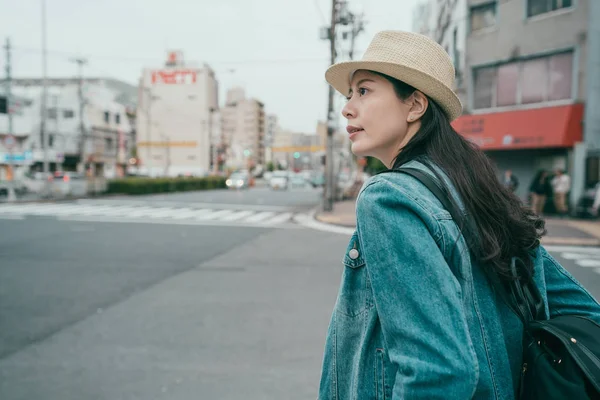 Nő kalap a hátizsák állva crosswalk — Stock Fotó