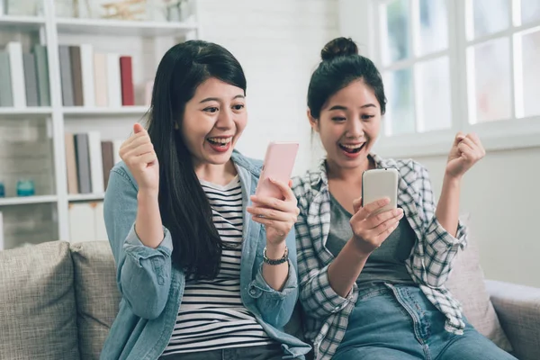 Amigos sentados en el sofá mirando el teléfono inteligente — Foto de Stock