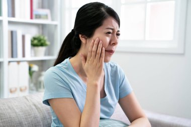 asyalı kadın kanepede oturan diş ağrısı var