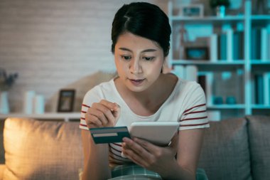 Kadın tablet bilgisayar ve kredi kartı kullanarak alışveriş yapıyor