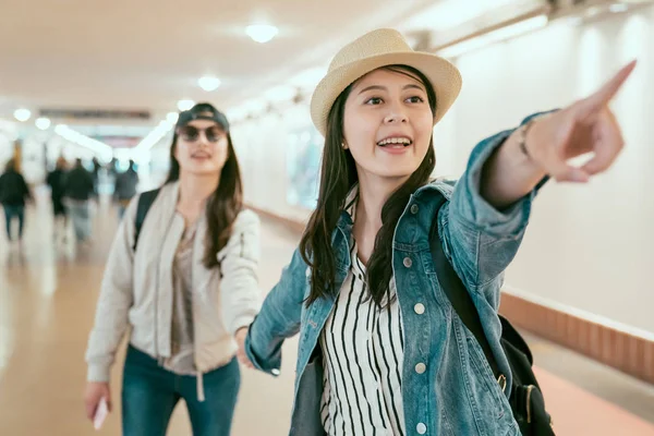 Friends tourists in passageway excited pointing — Stock Photo, Image