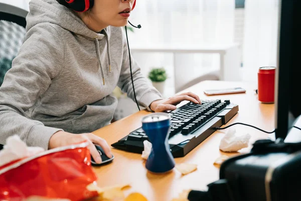 Student spelen online spel eten junk food. — Stockfoto