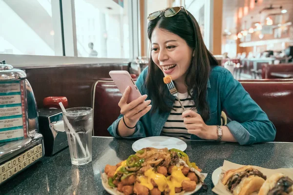 Girl traveler sitting in cafe using mobile phone — Stock Photo, Image