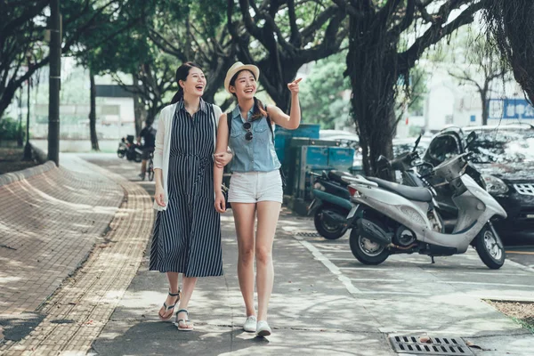 Két lány sétált a városi utcán fák alatt — Stock Fotó