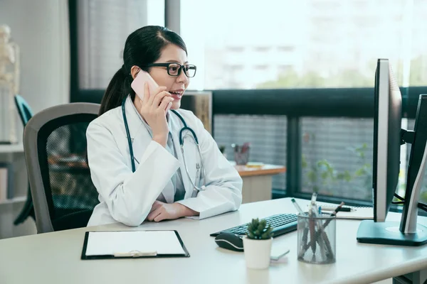 Asiatico femmina medico utilizzando cellulare parlare — Foto Stock