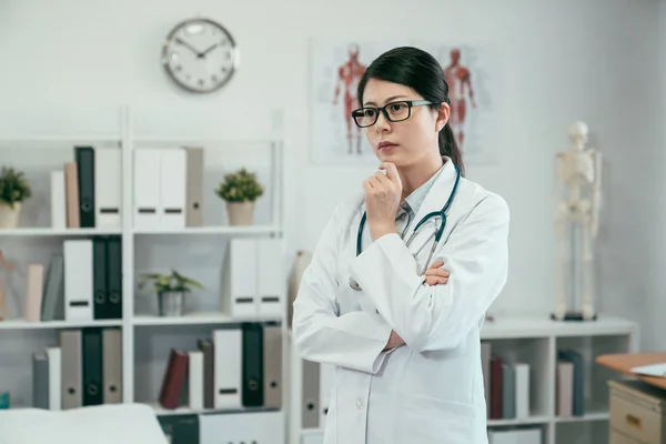 Premuroso asiatico donna medico standing in clinica — Foto Stock