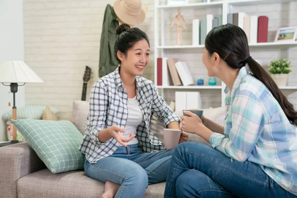 Vrouwen met koffie chatten op de bank roddelen — Stockfoto