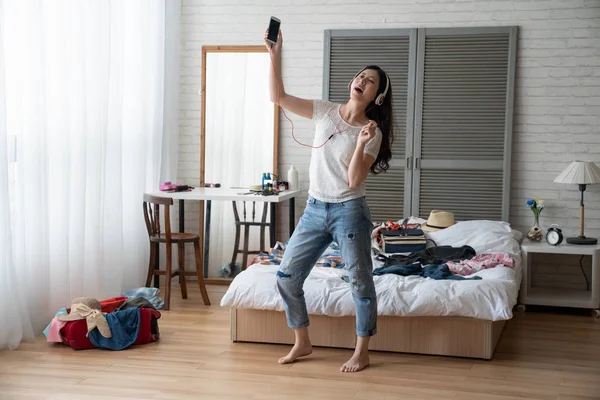 Mujer escuchar música desde el teléfono inteligente y bailar — Foto de Stock