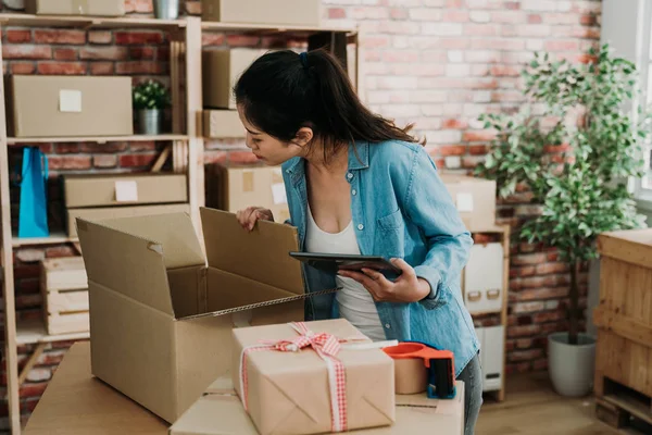 Vrouw werknemer werktablet met postpakket. — Stockfoto