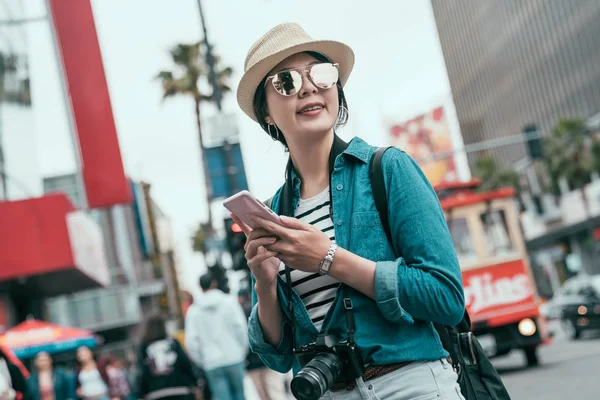Tourist smiling walking street using smartphone — Stock Photo, Image