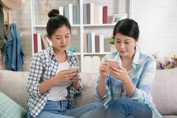 Jóvenes asiáticas hermanas obsesionado con los teléfonos inteligentes — Foto de Stock