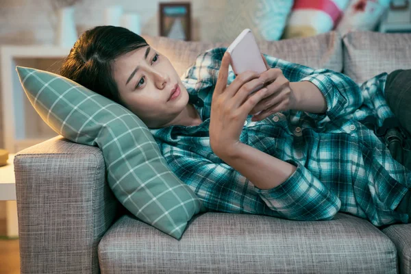 Mujer agotada triste mintiendo usando el teléfono inteligente — Foto de Stock