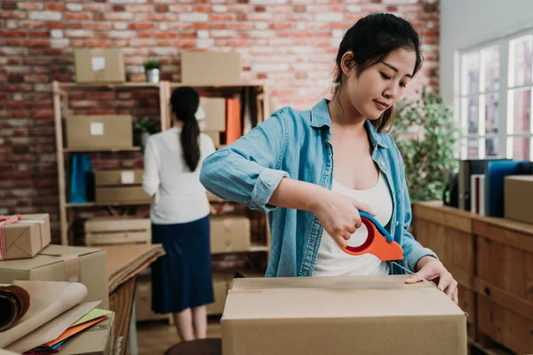 Vrouw eigenaar verpakking karton op de werkplek — Stockfoto