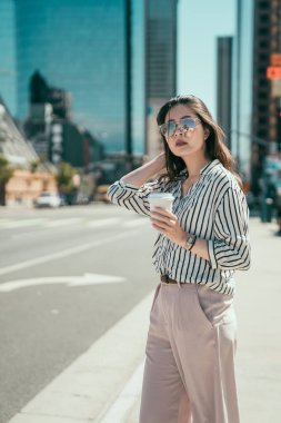 sokakta kahve bir fincan tutan kız