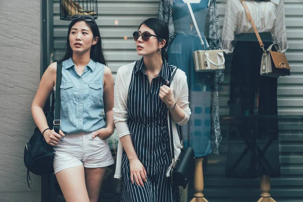 Vrouwen kijken weg leunend op etalage — Stockfoto