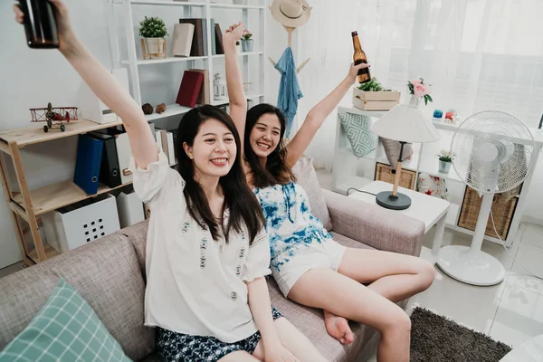 Mujeres viendo la televisión levantar las manos con cerveza helada — Foto de Stock