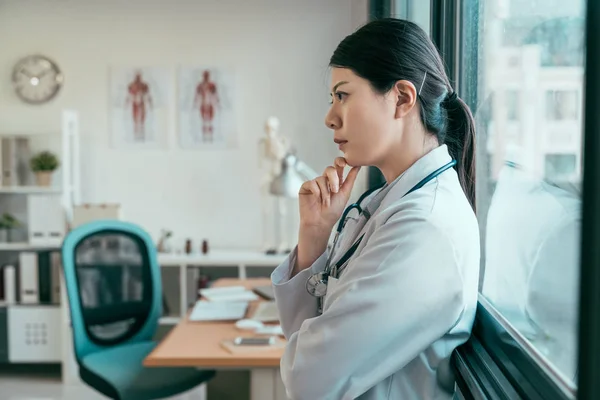 Medico donna premuroso in clinica finestra pendente — Foto Stock