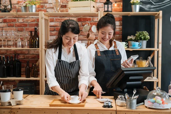 Barista y cajero hablando detrás del mostrador de la barra — Foto de Stock