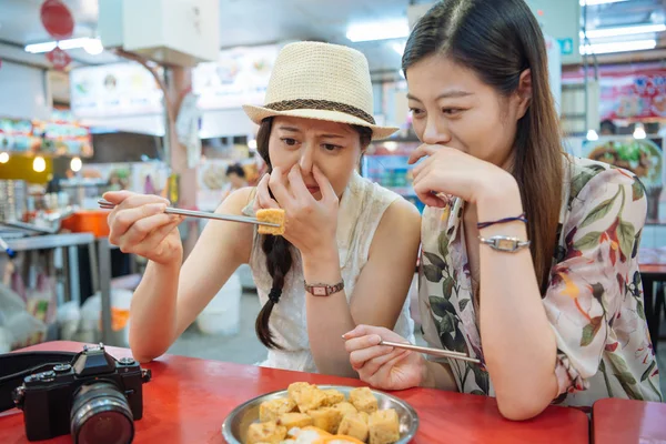 Foreigner female travelers trying stinky tofu — Stock Photo, Image