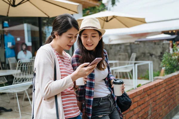 Women sit lean on red brick wall in outdoor cafe — Stock Photo, Image