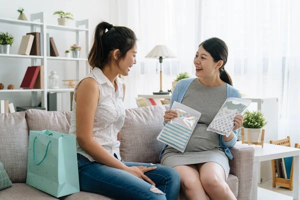 girl send baby clothes as present in baby shower