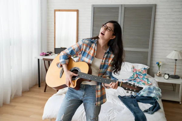 Mujer atractiva tocando la guitarra en casa — Foto de Stock