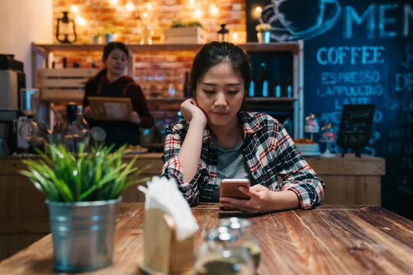 Young woman texting on mobile phone at bar — Stock Photo, Image