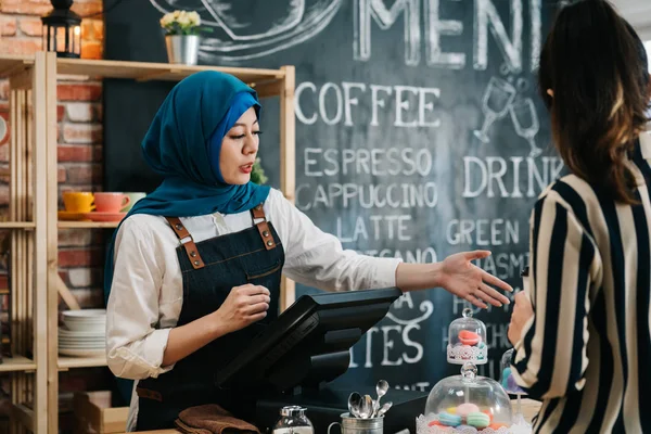 Camarera árabe recomendando mujer de negocios — Foto de Stock