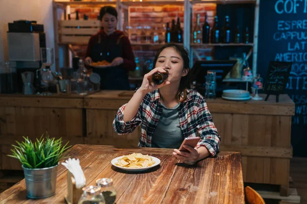 Woman with phone drink beer read message at bar — Stock Photo, Image