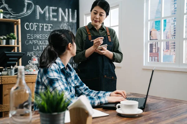 Lachende serveerster slijtage schort nemen orde in café — Stockfoto