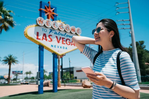 Happy Tourist använda mobiltelefon i solen flare. — Stockfoto