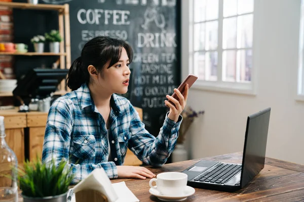 Girl open eyes big while check time on cellphone — Stock Photo, Image