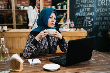 arap kadın çay içmek ve dizüstü bilgisayar kullanarak