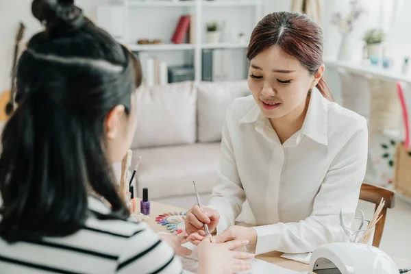 Female manicurist careful cleaning cuticle — Stock Photo, Image