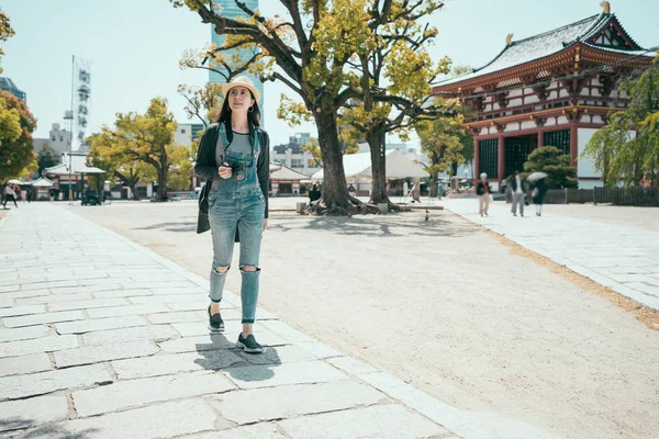 Tourist wearing hat and backpack walking around — Stock Photo, Image