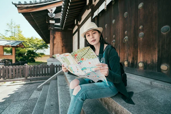 Viajero con mochila y sombrero mirando mapa de papel — Foto de Stock