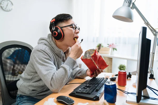 Jogador masculino engraçado come lanches de pacote — Fotografia de Stock