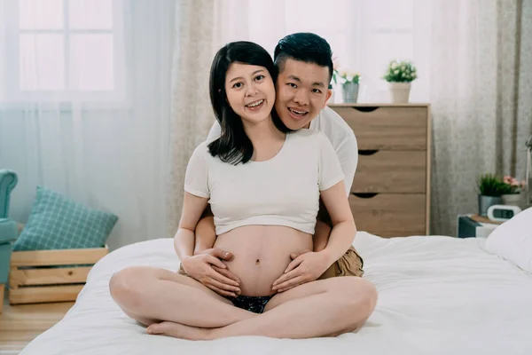 Hombre guapo y hermosa esposa embarazada abrazándose — Foto de Stock
