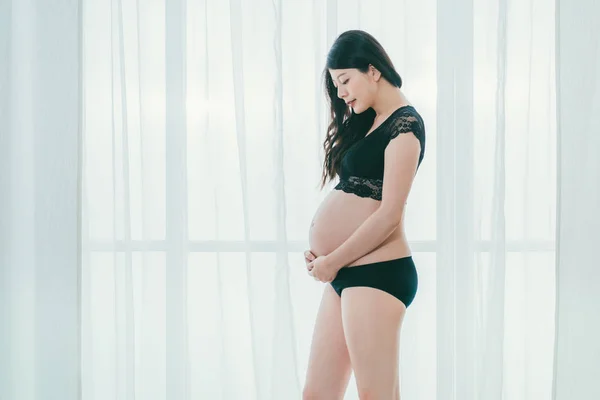 Senhora grávida em pose elegante em sutiã preto — Fotografia de Stock