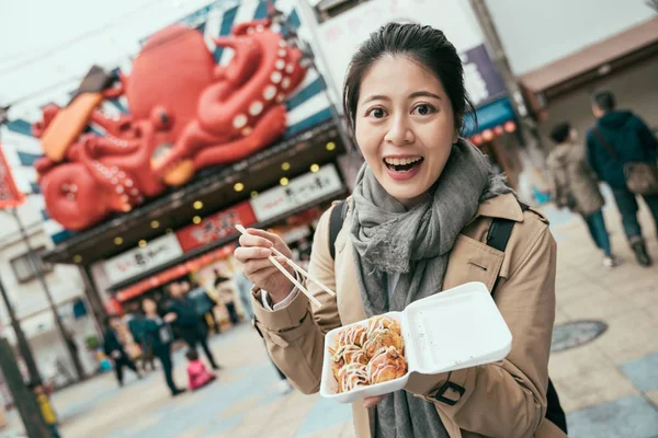 Takoyaki in box on hands of young happy woman — Stock Photo, Image