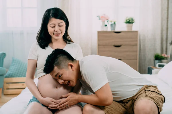 Feliz hombre escuchar hermosa embarazada esposa vientre — Foto de Stock