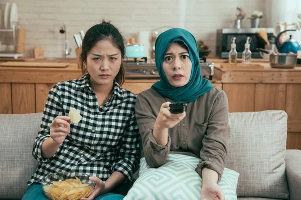 Compañeros de cuarto comiendo patatas fritas mientras juego de película de terror — Foto de Stock